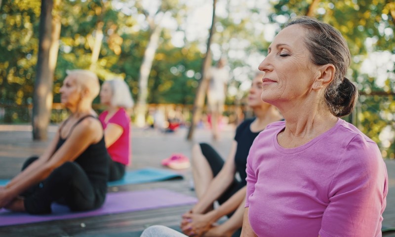 Starije žene rade jogu u prirodi